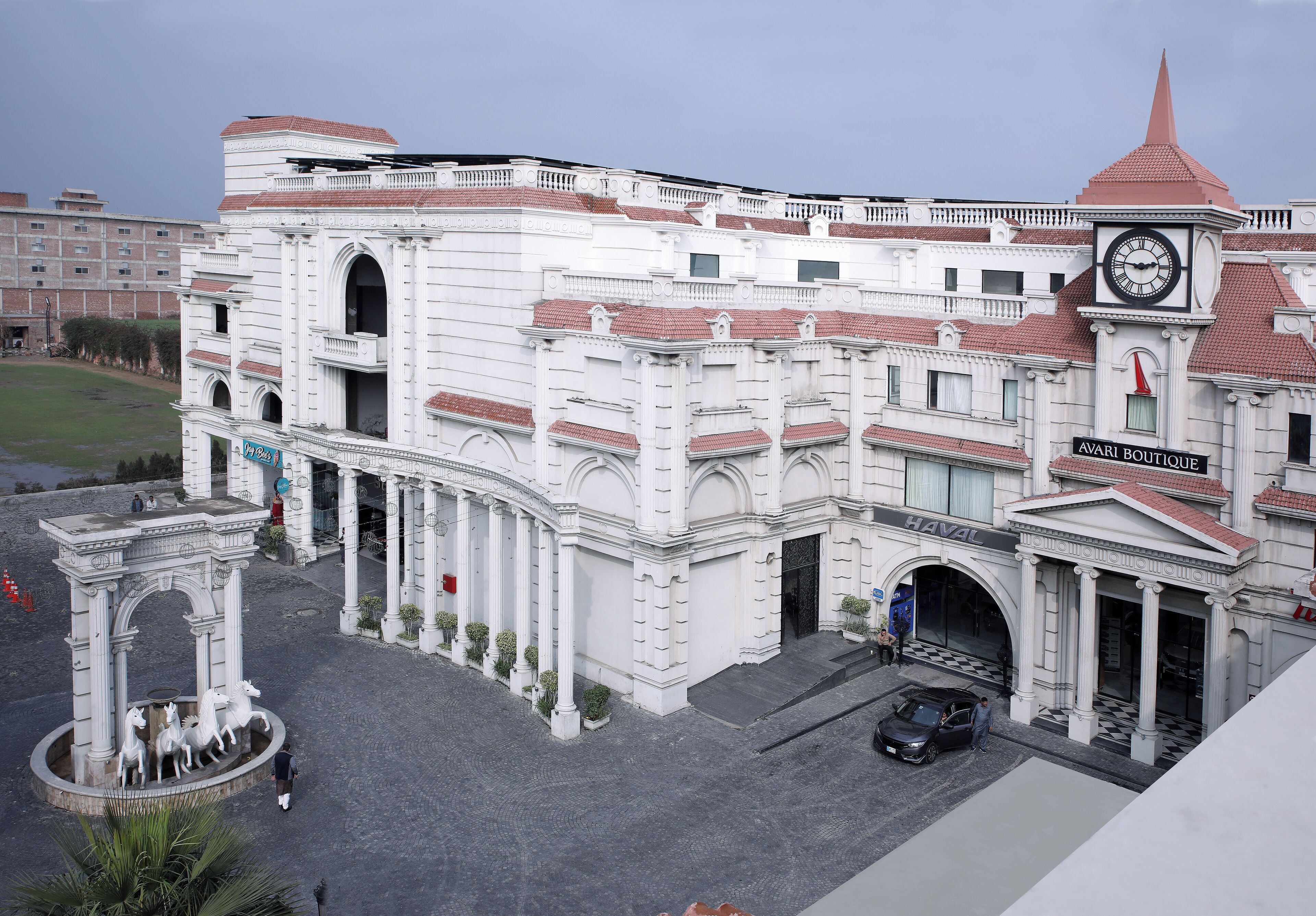 Un bâtiment historique doté d’une tour horlogée, d’une arche et d’une enseigne indiquant la présence d’un hôtel-boutique.