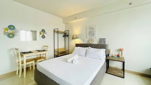A hotel room with a bed, a desk, and a chair. - Spacious & Relaxing Haven (Iloilo)