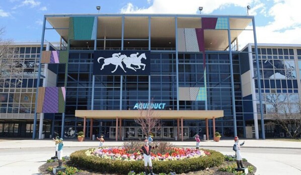 Un edificio moderno junto a una pista de carreras de caballos.