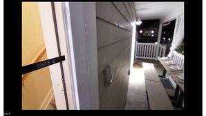 A corridor with a sign reading "SUITE B" leading to a balcony area with outdoor seating. - Charming 2-bedroom apartment in Arverne by the Sea (Arverne)