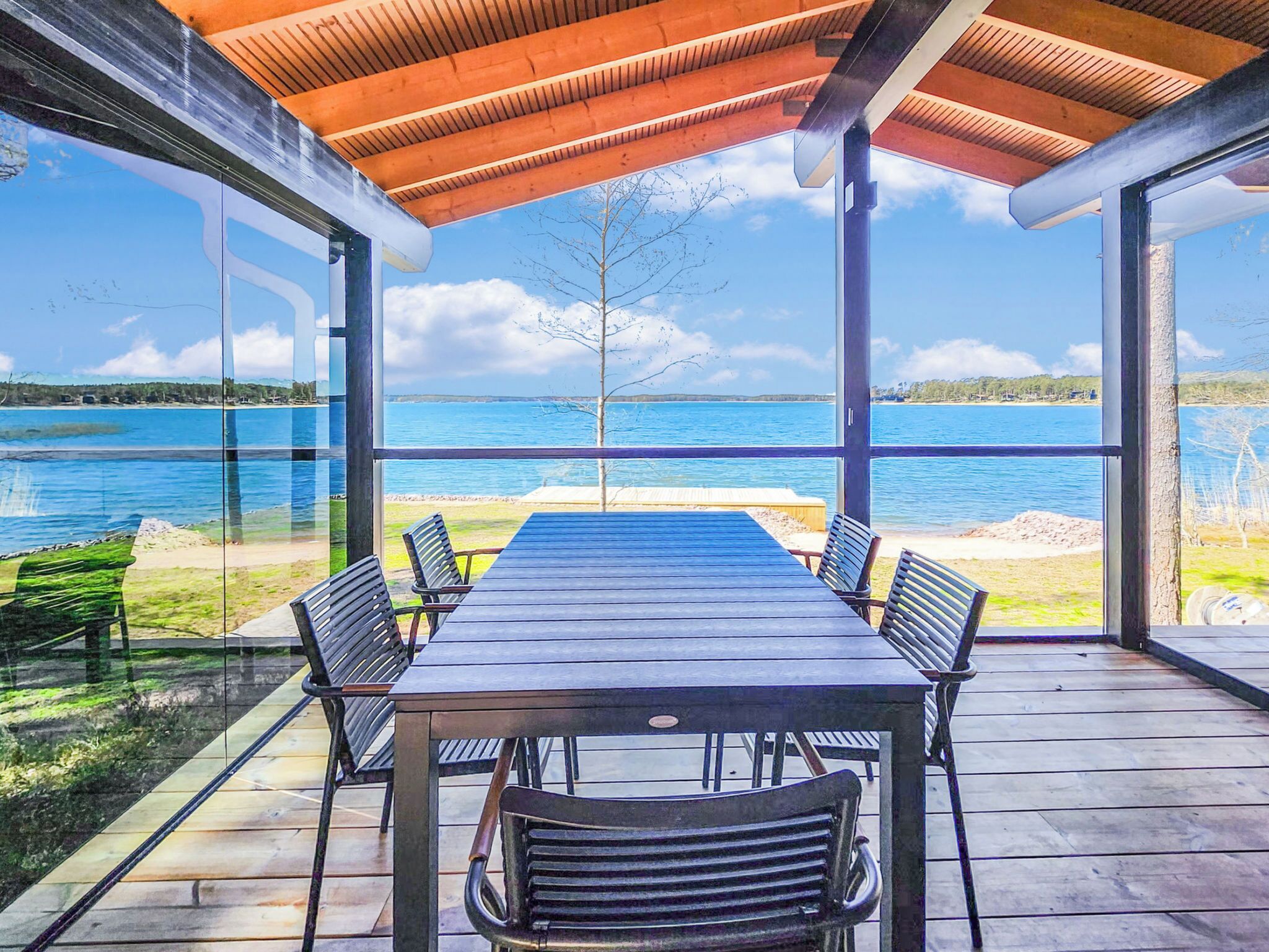 An outdoor dining area with a view of a lake and distant land.