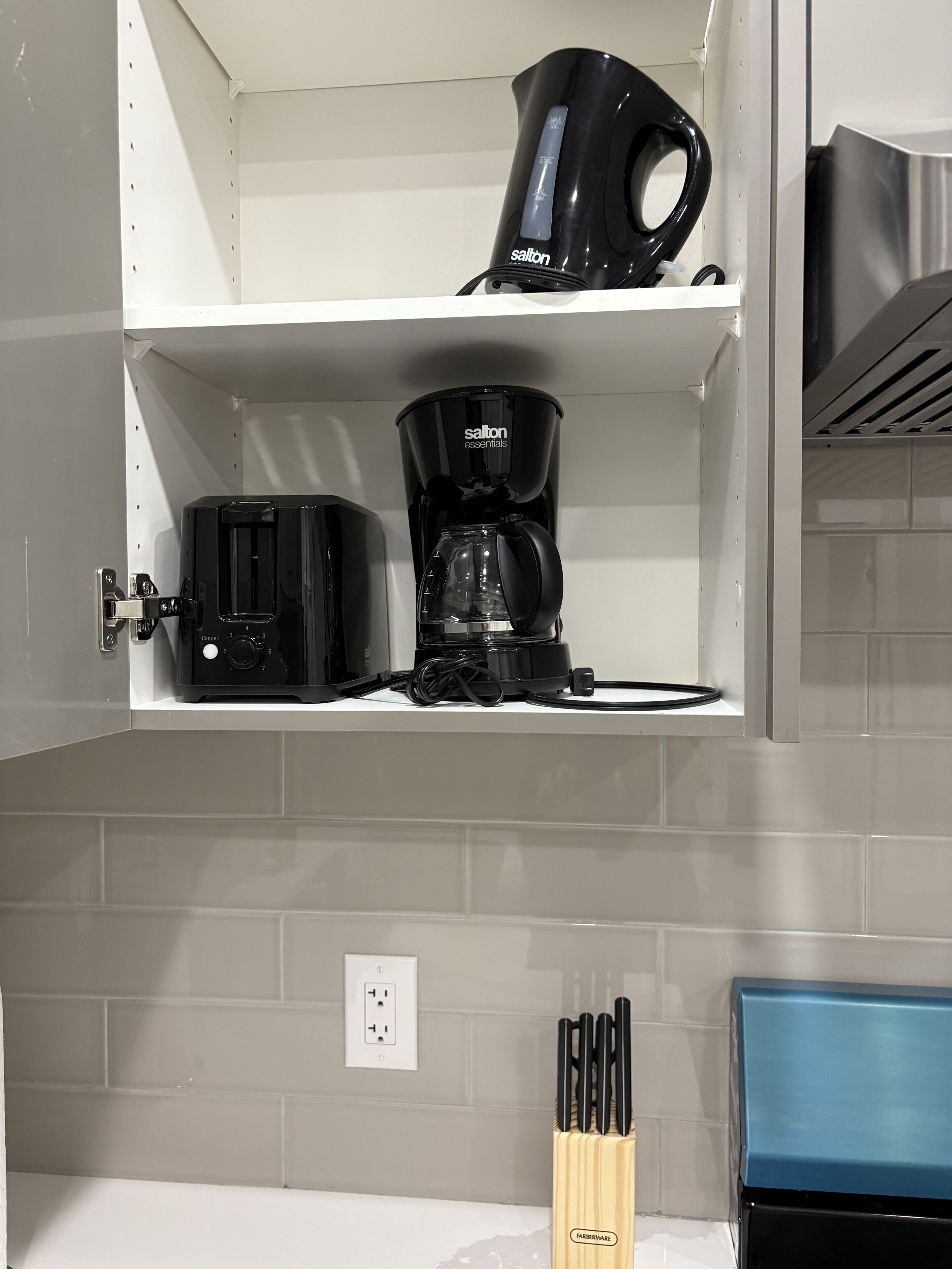 Eine Küche mit Kaffeemaschine, Toaster und einem Messerblock auf der Arbeitsfläche.