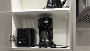 A kitchen with a coffee maker, toaster, and knife block on the counter. - Cozy, clean and homely (Calgary)