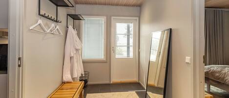 Un dormitorio con cama, mesita de noche, espejo y ventana con persianas.