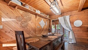 Un interior de madera con una mesa de comedor, sillas y un banco.