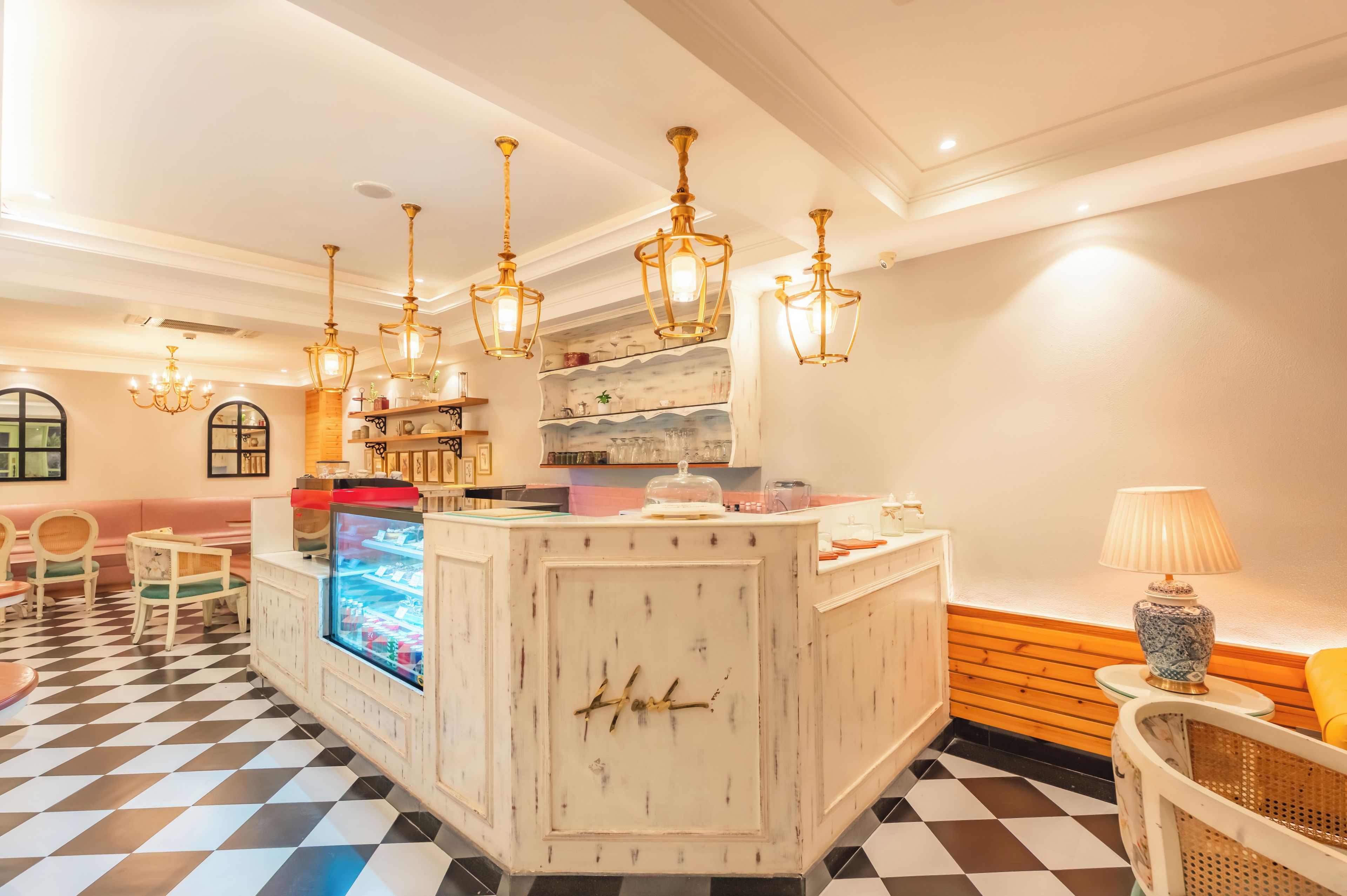 Een hotel lobby met een receptiebalie, een zithoek en decoratieve verlichting.