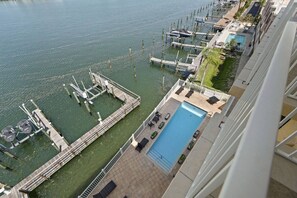 A high-rise hotel with a rooftop pool, a marina with docks, and a view of the water.