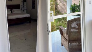 A bedroom with a bed, a nightstand, and a wall-mounted air conditioner.