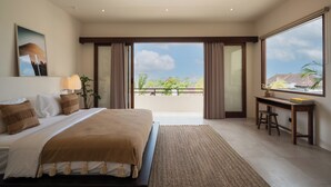 A modern bedroom with a large bed, a desk, and a view of the outdoors. - Rumah Tiha by Alfred in Bali (Canggu)