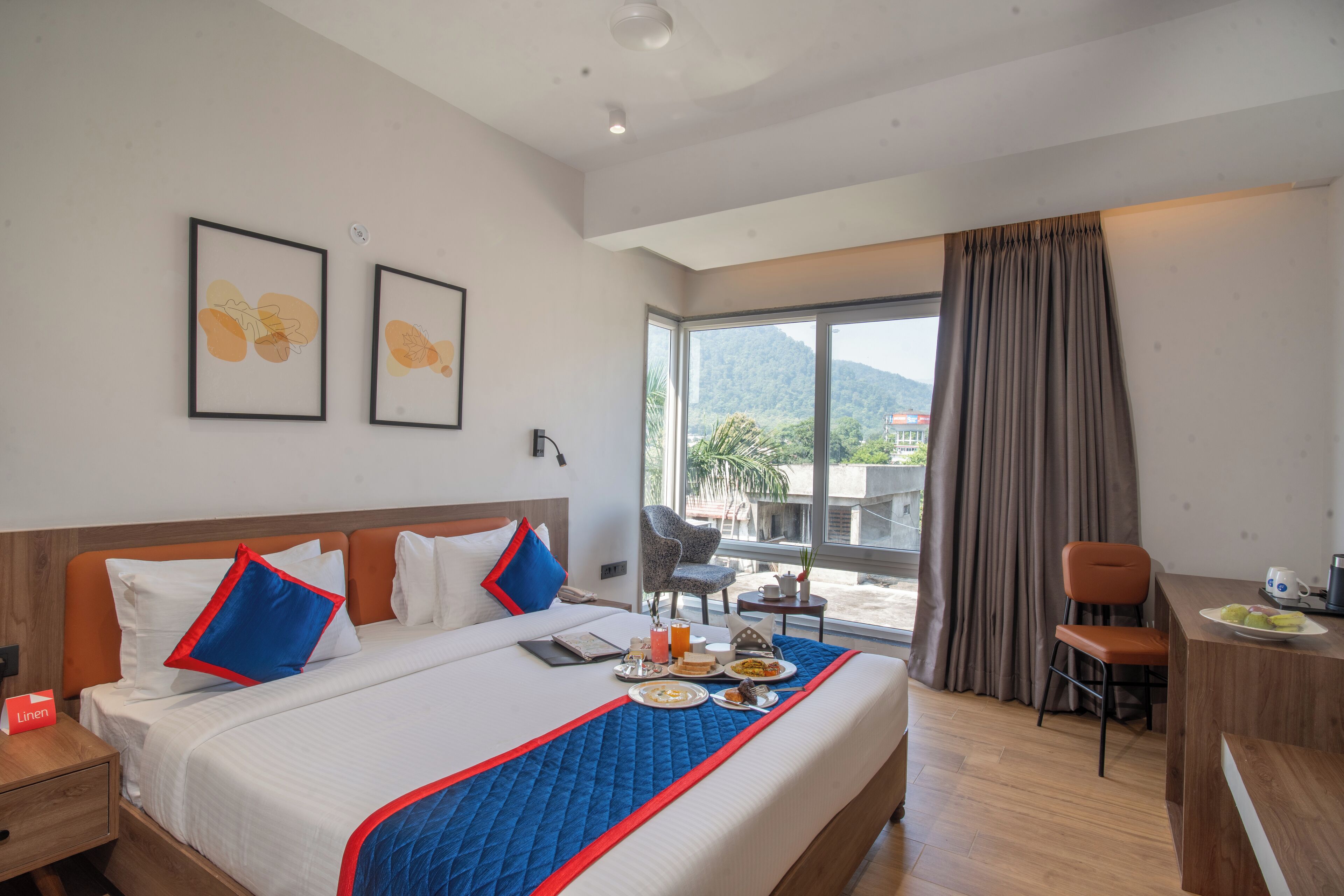 A hotel room with a large bed, a desk, and a view of the outdoors.