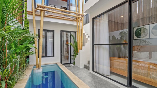 Un interior moderno con piscina, escalera y un amplio ventanal con cama.
