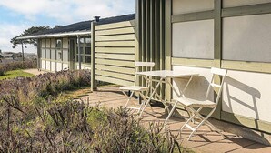 A building with a covered patio area featuring a table and chairs. - 4 Person Holiday Park Home in Gilleleje (Gilleleje)