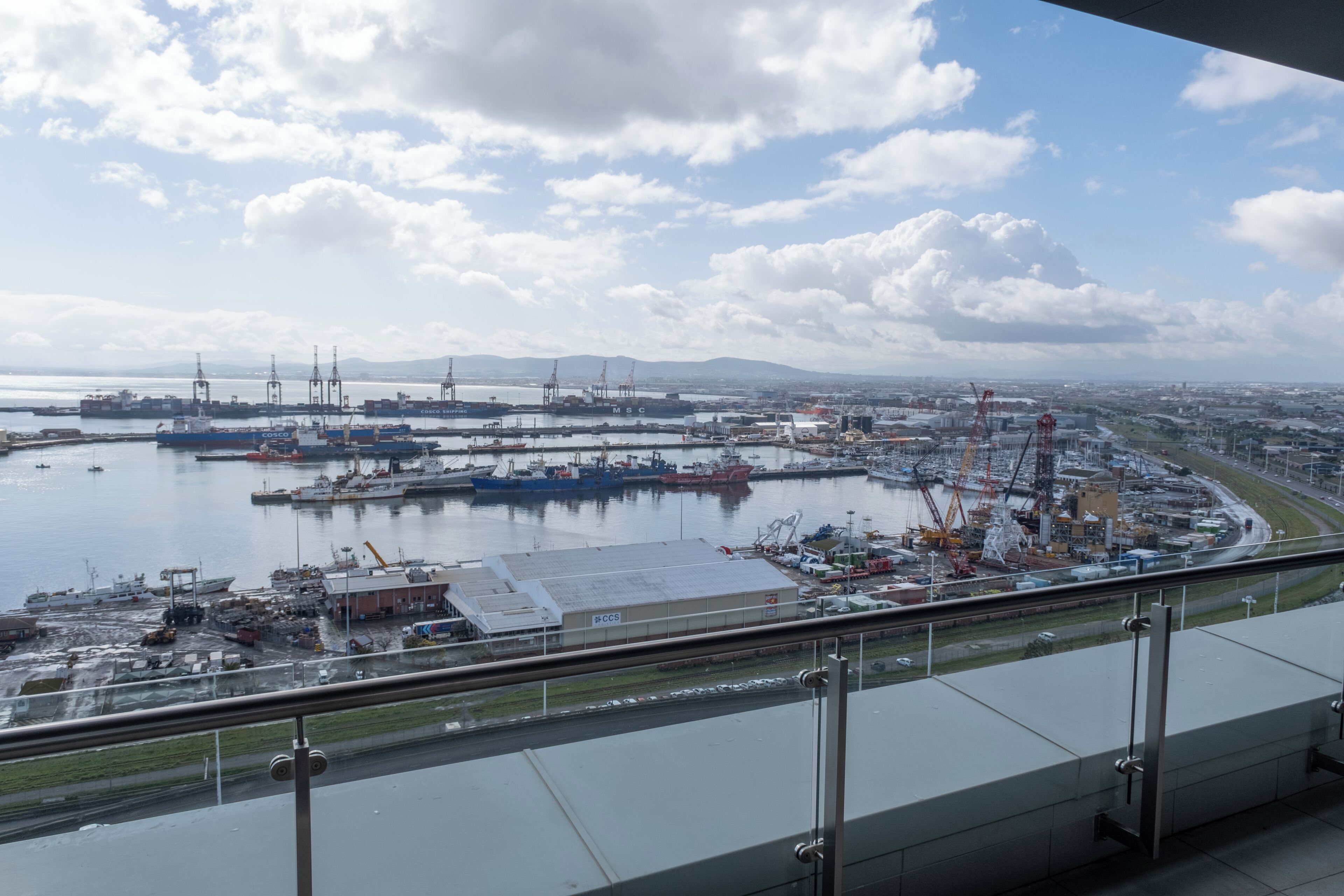 A port with ships, cranes, and industrial buildings.