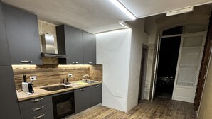 Una cucina moderna con mobili grigi, un piano di lavoro in legno e un forno integrato.