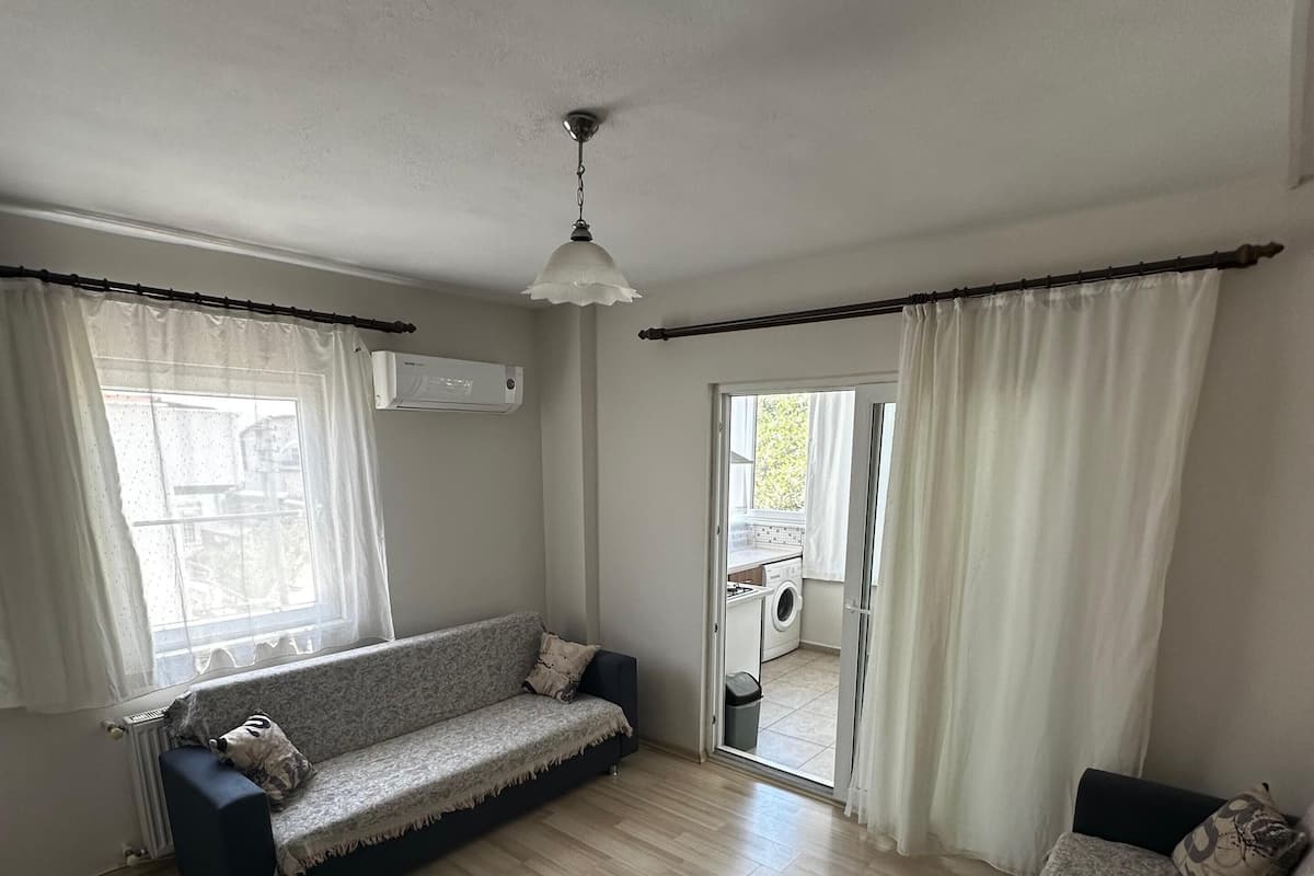 Ein Wohnzimmer mit einer Couch, einem Couchtisch und Blick ins Freie.