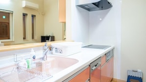 A modern kitchen with a white countertop, stainless steel sink, and orange cabinets. - Yunosato699-89 (Rankoshi)