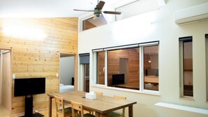 A dining area with a wooden table and chairs, a ceiling fan, and large windows. - Yunosato699-89 (Rankoshi)