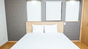 A hotel room with a large bed, a wooden headboard, and two windows with blinds. - Yunosato699-89 (Rankoshi)