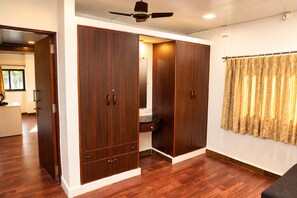 A room with a wardrobe, a ceiling fan, and a window with curtains. - Omnia Beach Resort Near Candolim Beach (Candolim)