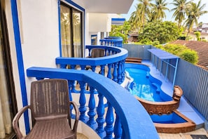 A pool area with blue railings and chairs, surrounded by greenery and buildings. - Omnia Beach Resort Near Candolim Beach (Candolim)