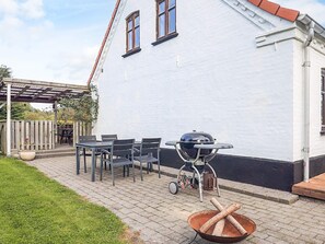 A patio with a grill, chairs, and a table. - 4 Star Holiday Home in Asaa (Asaa)