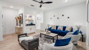 A modern living room with a blue sofa, grey armchairs, and a coffee table.
