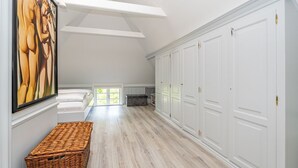 A spacious hallway with a high ceiling, white walls, and a large wardrobe. - Kapitänshuis - Captain's house on Sylt with garden, terrace and comfortable (Sylt)