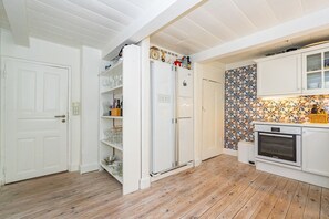 Une cuisine avec des armoires blanches, un four encastré et un pare-feu décoratif.