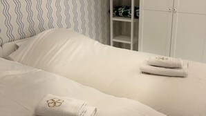 Una cama bien hecha con dos toallas dobladas y una almohada a juego.