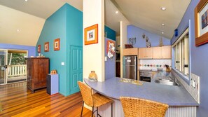 A modern kitchen with a curved island, wooden cabinets, and a built-in oven. - MiaCasa - by Lifestyle. Brunswick Heads (NEW BRIGHTON)