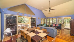 A spacious living area with a high ceiling, a dining table with woven chairs, a sofa, and a ceiling fan. - MiaCasa - by Lifestyle. Brunswick Heads (NEW BRIGHTON)
