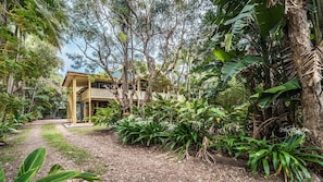 A wooden house with a porch, surrounded by dense tropical vegetation. - MiaCasa - by Lifestyle. Brunswick Heads (NEW BRIGHTON)