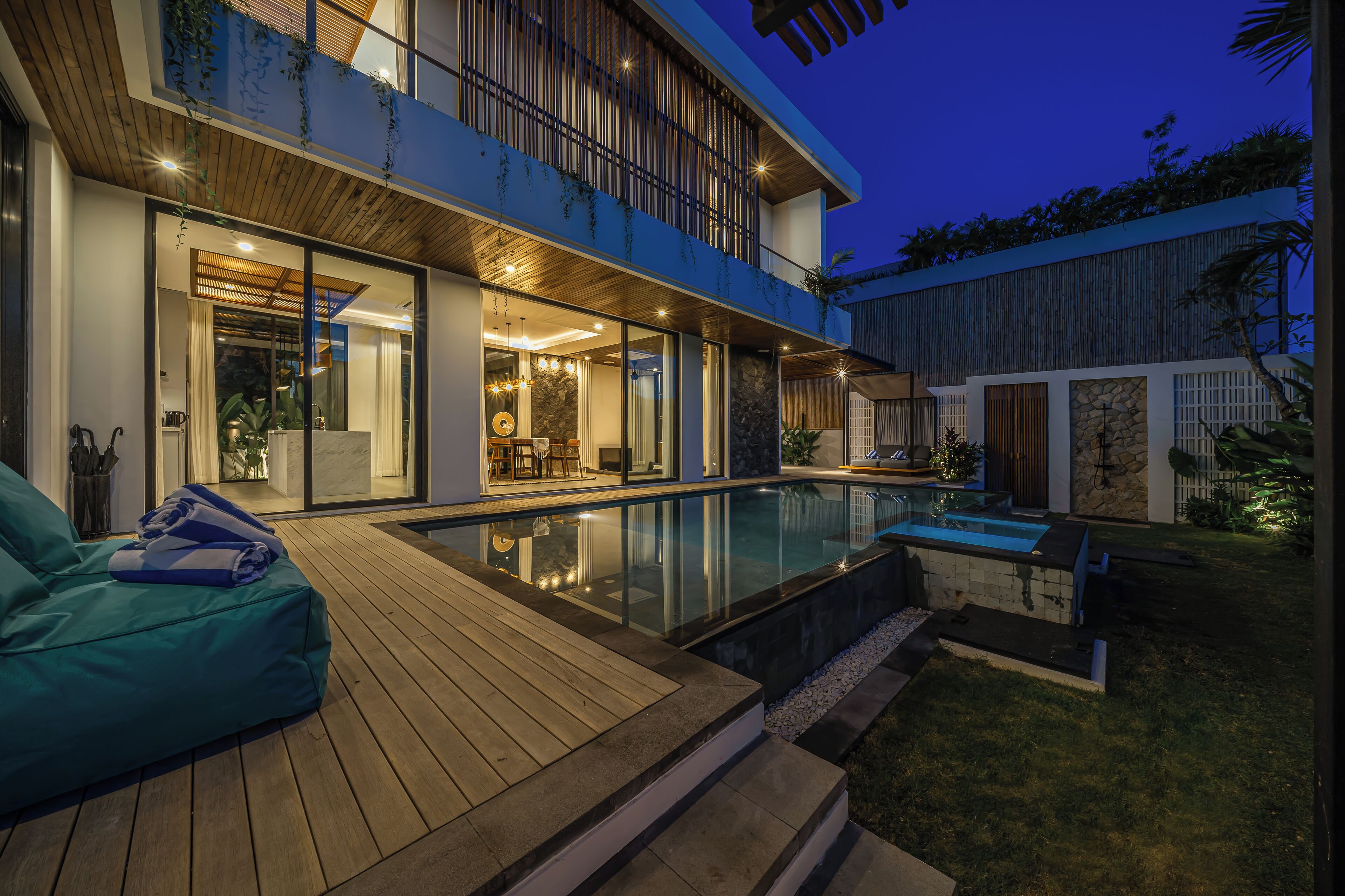 Une maison moderne dotée d’une piscine, d’une terrasse en bois et d’un balcon.