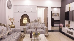 Un salon comprenant un canapé, un fauteuil décoratif, une horloge murale et un meuble.