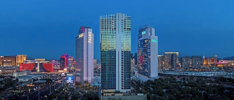 Paisagem urbana com edifícios altos, incluindo um hotel com a placa 'PALMS'.