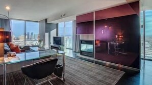 A modern hotel room with a glass desk, a flat-screen TV, and a city view. - Palms Luxury Strip View 1BD/1.5BA Open Balcony#22KA (Las Vegas)