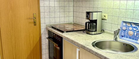 Een koelkast, een oven, een kookplaat, een koffiezetapparaat/waterkoker