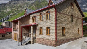 Un edificio de piedra con techo rojo y una escalera que lleva a un balcón.