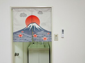 A bathroom with a traditional Japanese sliding door featuring a Mount Fuji and cherry blossoms design. - CU Host CASA (Osaka)