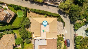Eine Vogelperspektive zeigt eine Wohngegend mit einem Haus, das ein Ziegeldach und einen Innenhof hat.