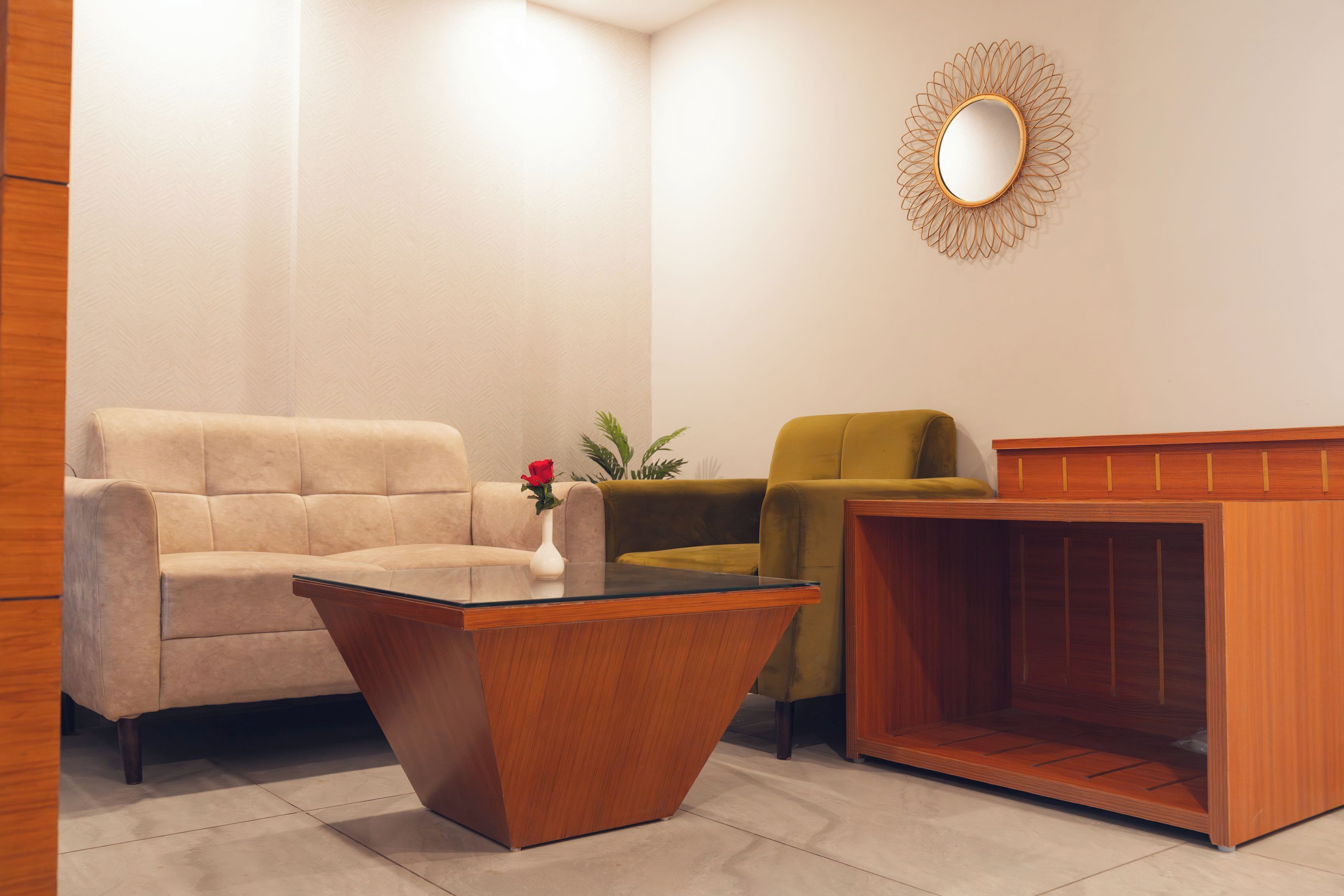 Un soggiorno moderno con un divano color beige, una poltrona verde, un tavolino in legno e un camino.