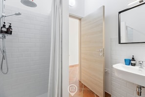 Chuveiro, bidê, toalhas de banho, shampoo