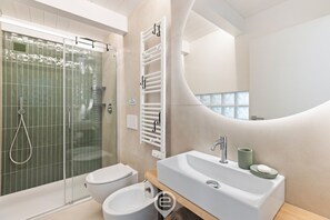 Chuveiro, bidê, toalhas de banho, shampoo