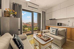 A modern apartment with a living area, kitchen, and balcony with a city view. - The West Lake Serenity'N Homestay Ha Noi (Hanoi)