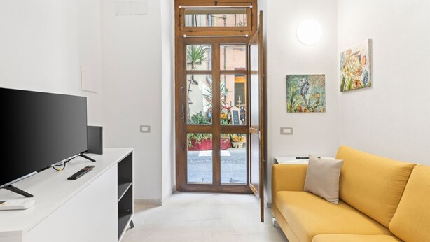 Una sala de estar moderna con una televisión de pantalla plana, un sofá y obras de arte en las paredes.