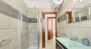 Een douche, een bidet, handdoeken, shampoo