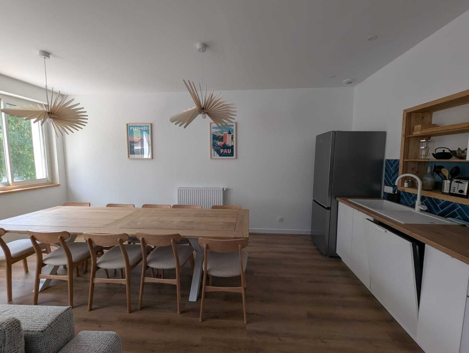 A modern kitchen with a built-in refrigerator, wooden cabinets, and a white countertop.