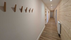 Un couloir avec des lambris en bois et des spots encastrés.
