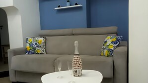 A modern living room with a grey sofa, a white coffee table, and blue walls.