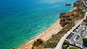 A coastal road with a beach and rocky cliffs. - Penthouse San Lorenzo (Portimão)
